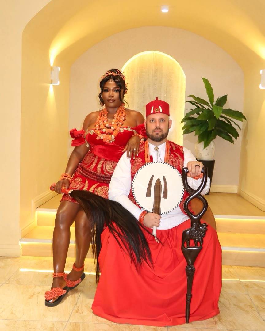Traditional ceremony, couple in red regalia holding ceremonial items