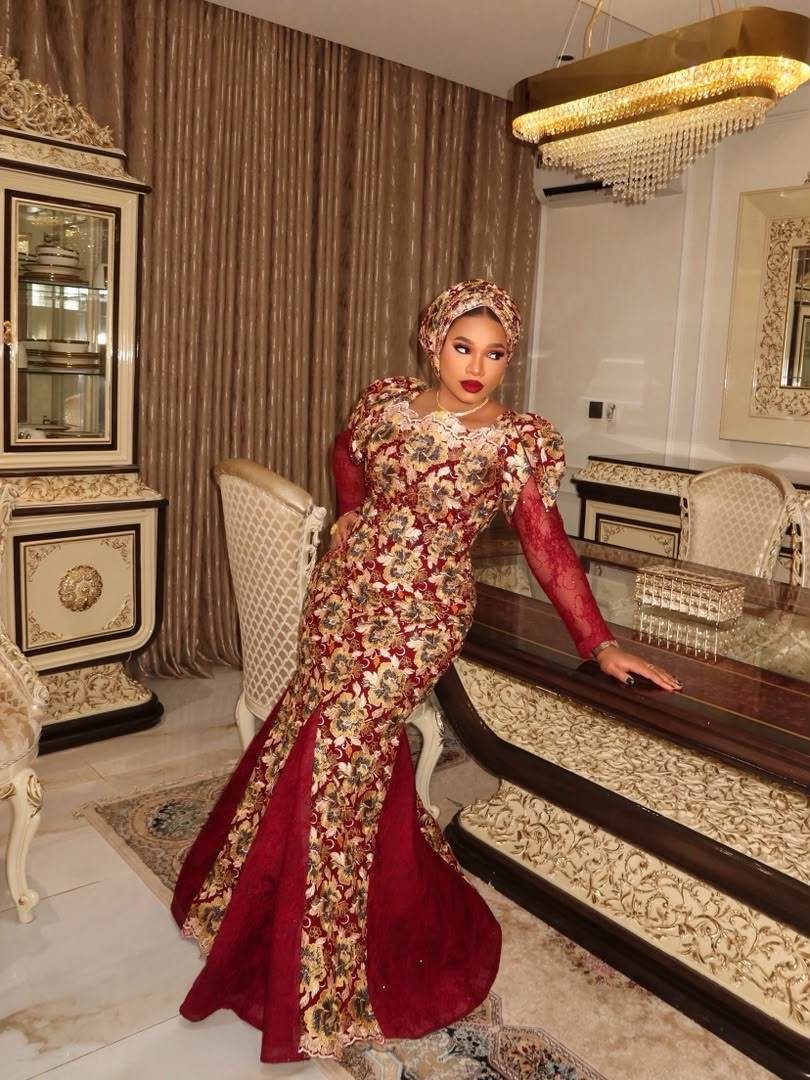 Bride in a red lace gown and traditional headwrap in an opulent interior