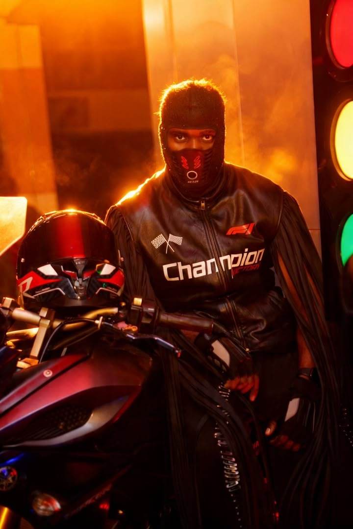 Dramatic editorial shot with a motorcycle, mask, and traffic lights