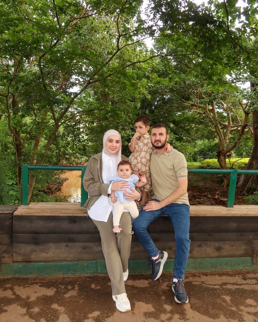 Family portrait of four outdoors among trees