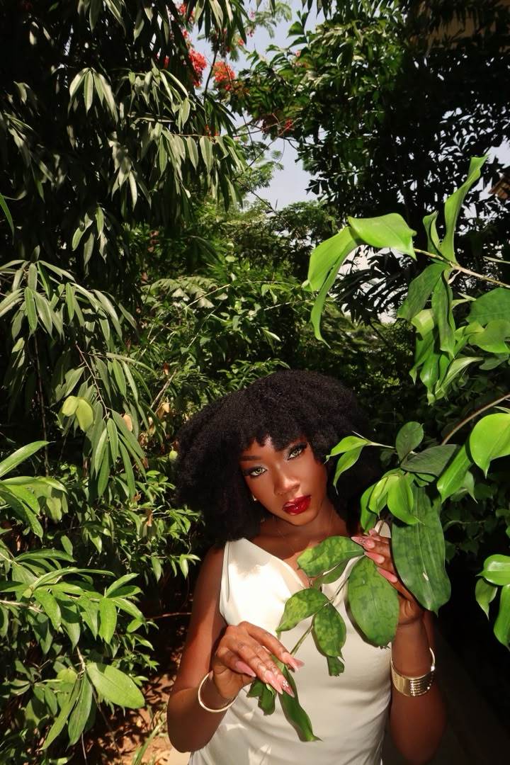 Editorial portrait in greenery, red lipstick, gold jewelry